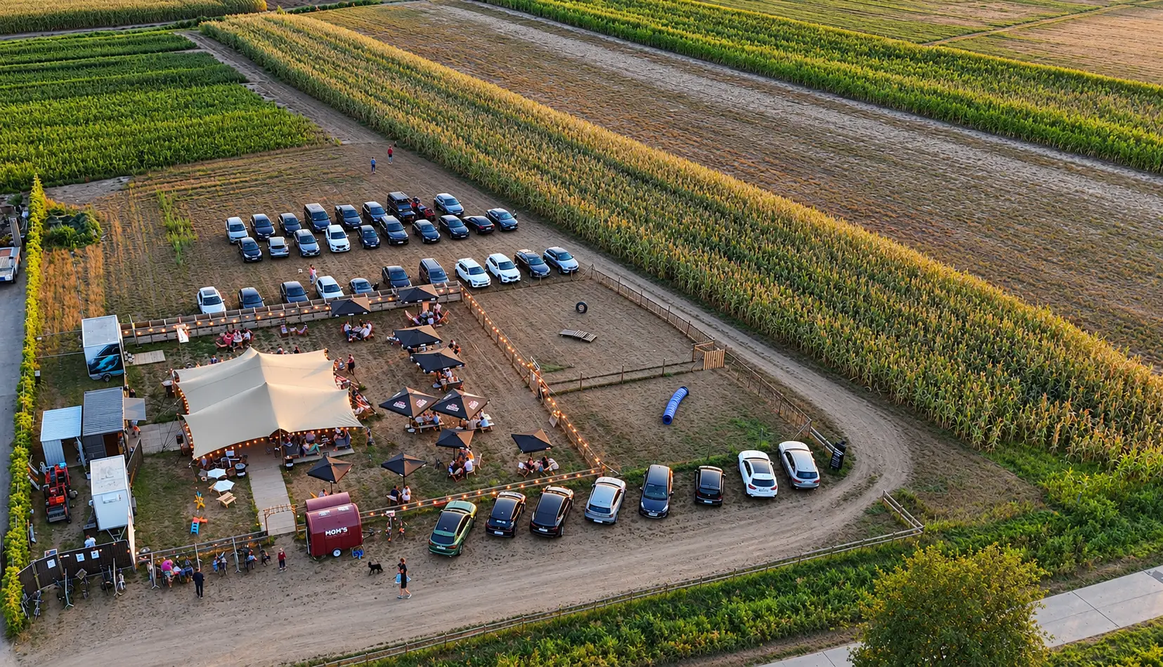 Dronefoto van BARk: de zomerbar, de losloopweide en de parking tussen de velden in Lievegem