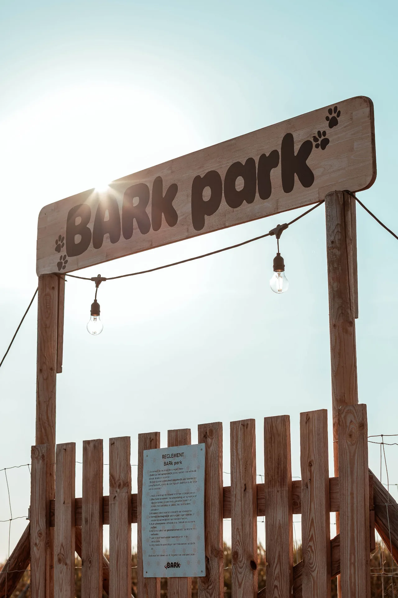 De houten toegangspoort van het BARk park in de avondzon