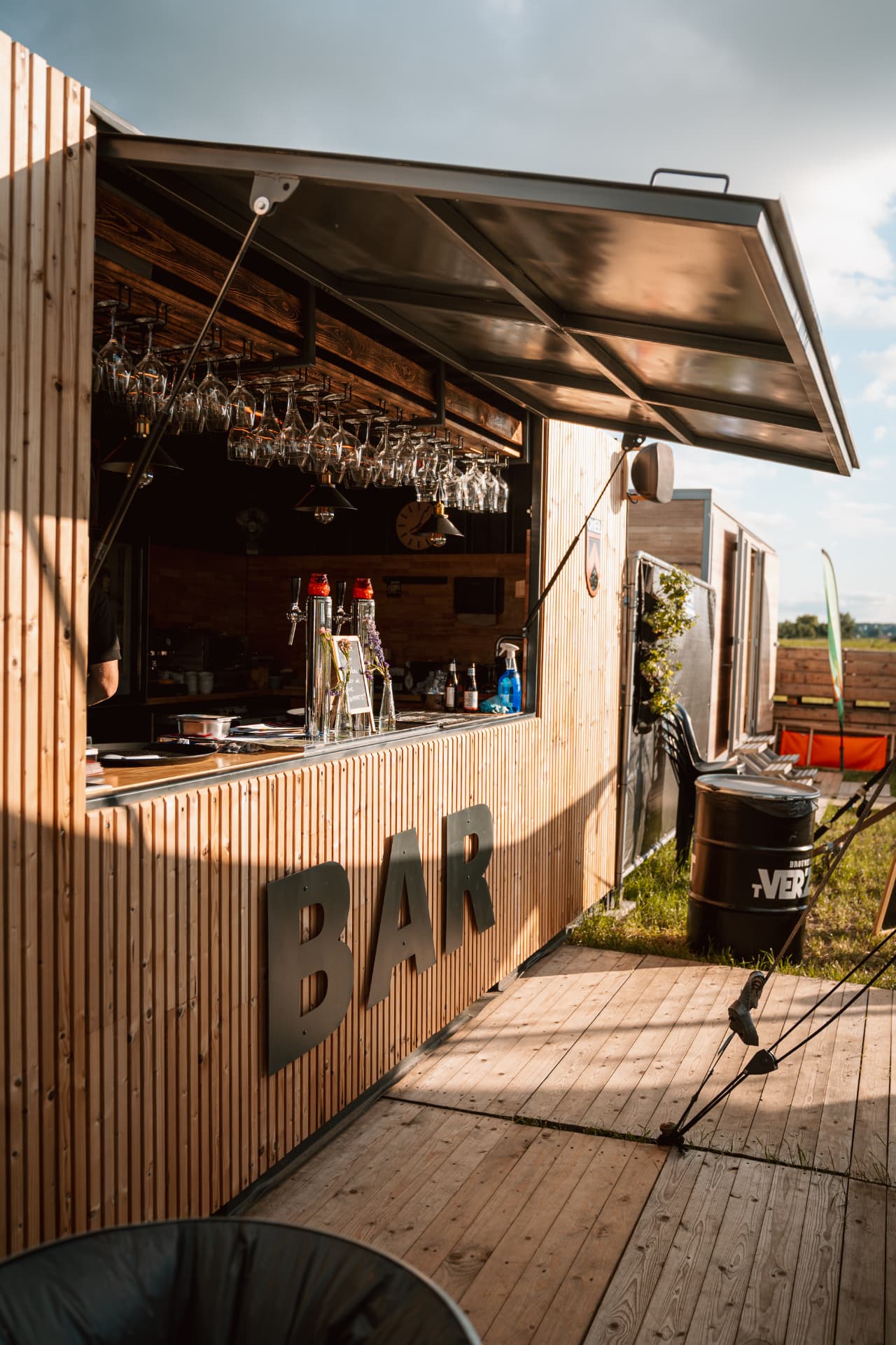De barcontainer met opengeklapte luifel, houten gevel en BAR-letters