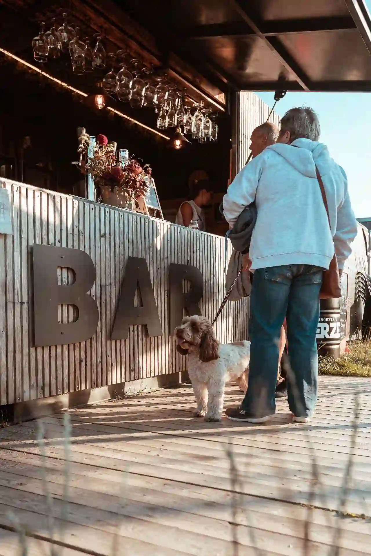 Bezoekers bestellen aan de toog met grote BAR-letters